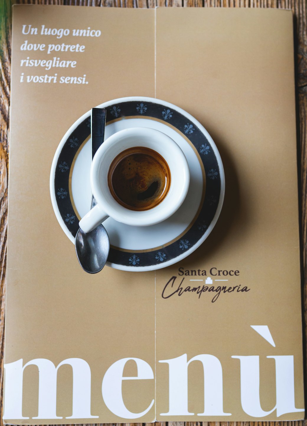 Caffè espresso in una tazza decorativa su un tavolo di legno.