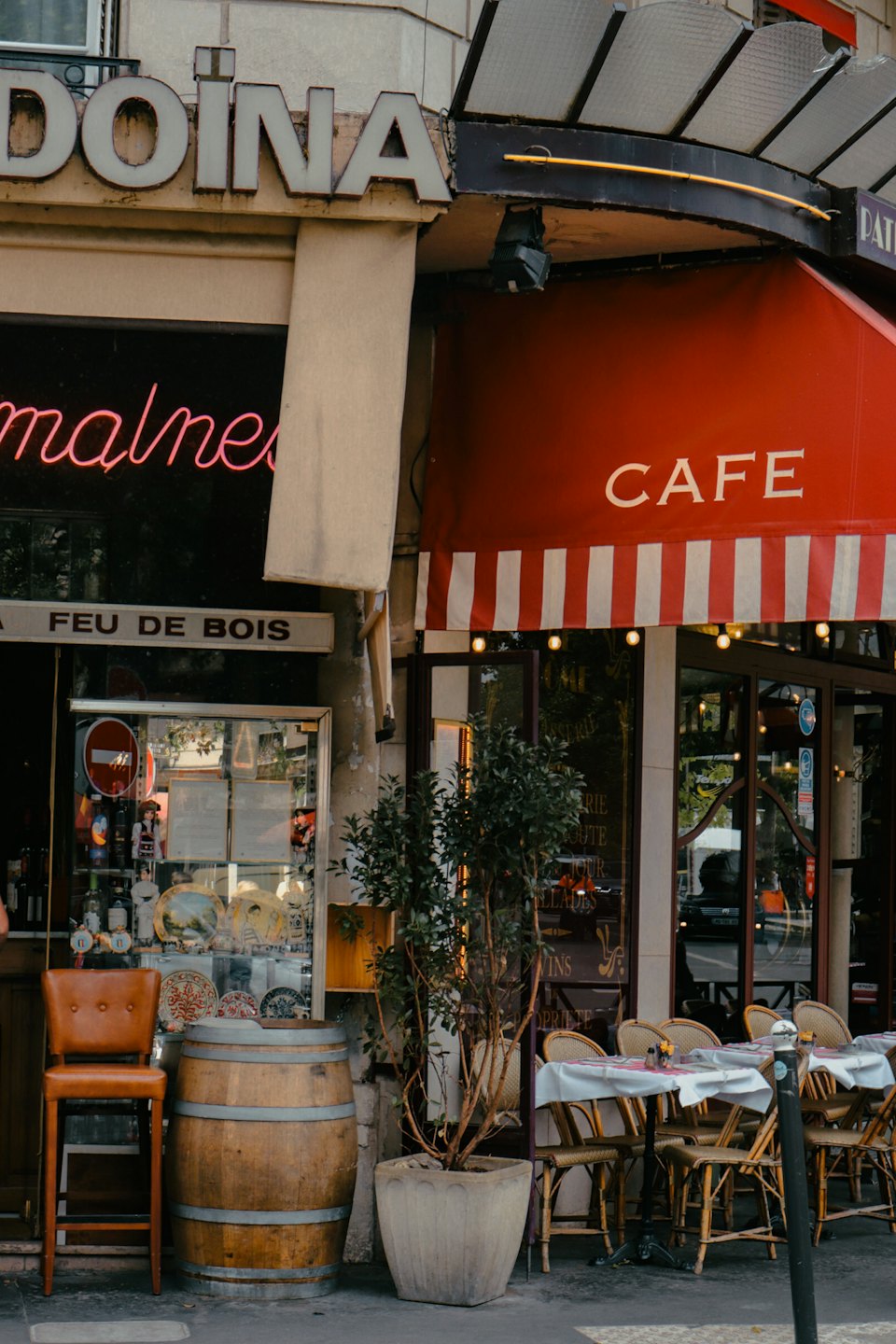 Esterno classico di un caffè con tenda a strisce e posti a sedere esterni in vimini.