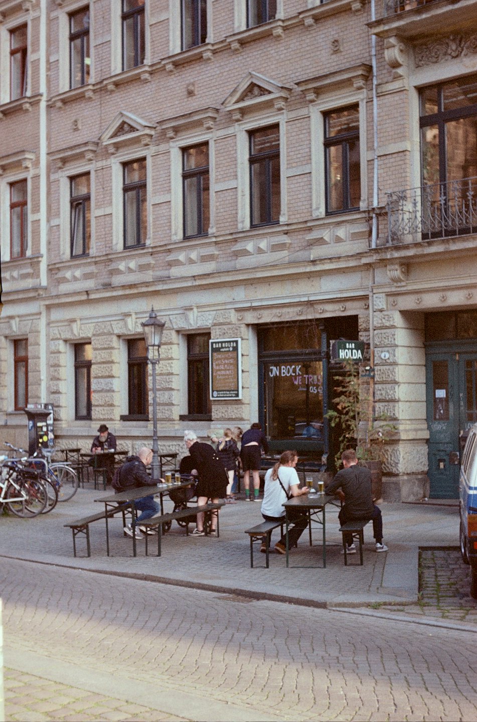 Persone che bevono ai tavoli fuori da un bar europeo.