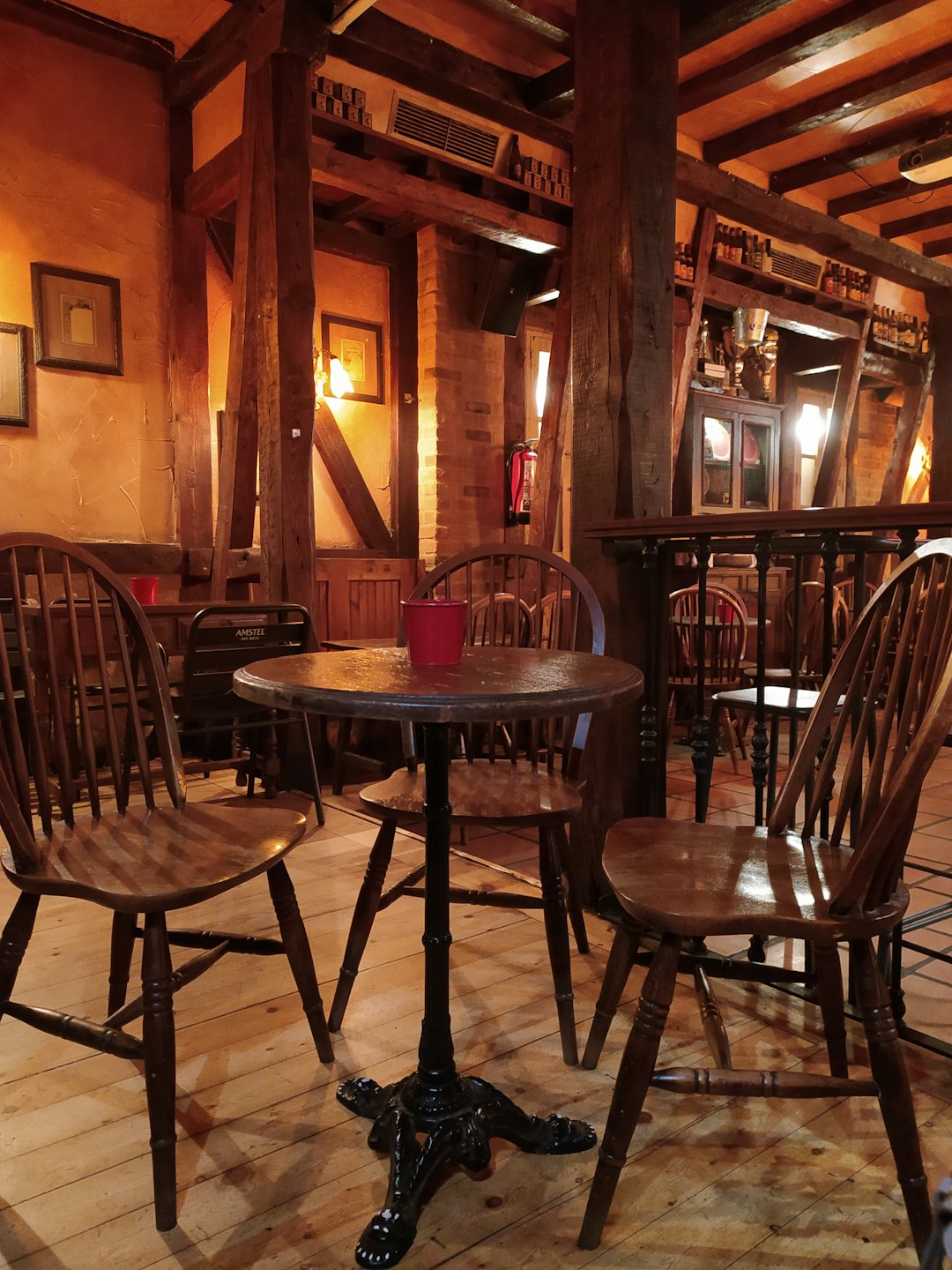 Interno accogliente di un bar rustico con tavoli e sedie in legno.